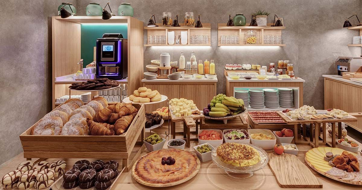 Buffet de desayuno con pastelería, fruta y embutidos
