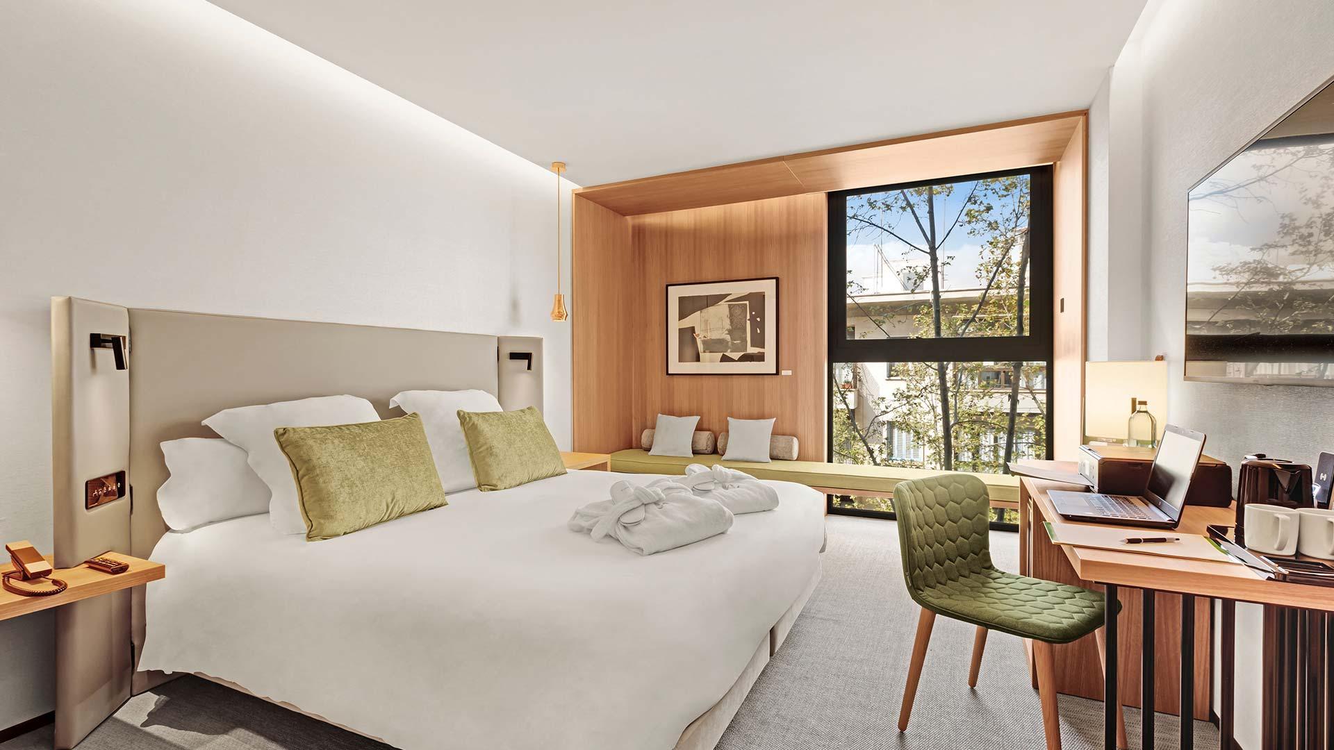 Habitación doble con cama grande y ventanal con árboles