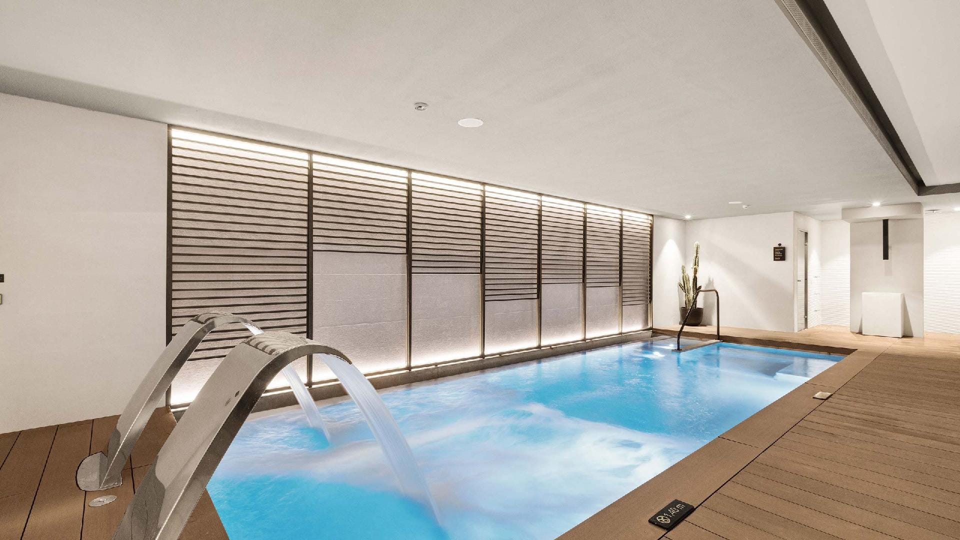Indoor spa pool with neck jets and an illuminated slatted wall